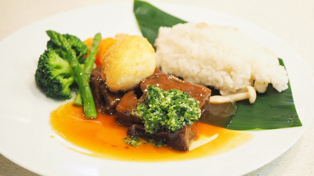 次はお肉料理。『“ロコモコ” ハレクラニスタイル 揚げ卵 きのこライス添え』(3,200円・消費税込み、別途サービス料を加算)。 こちらは2009年に登場したメニューです。